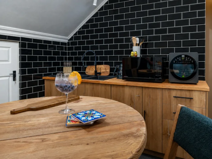 The overnight kitchenette upstairs in The BeeHive apartment, with a 3-seater table